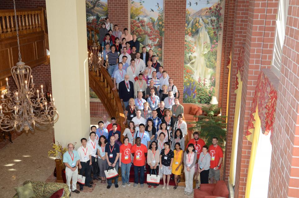 IMPS 2012 group photo, about 50 people indoors on a wooden staircase